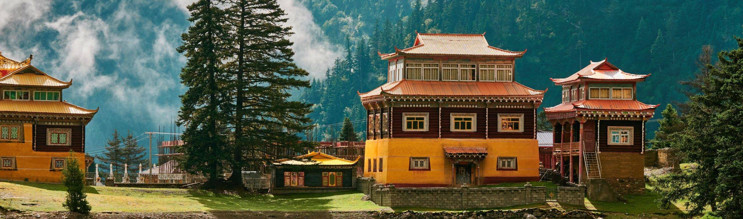 cuoka-lake-temple-located-in-Xinlong-County-Sichuan-Province-China-with-yellow-temple-buildings-pine-mountains-and-peaceful-wates